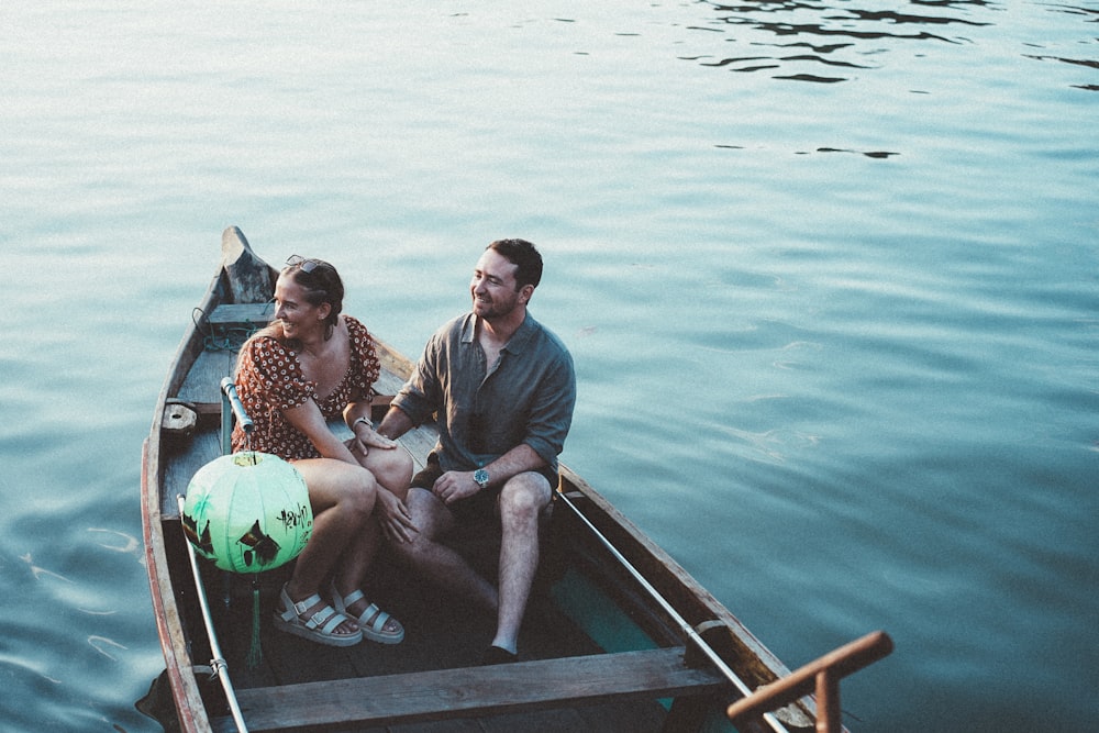 a man and a woman sitting in a small boat