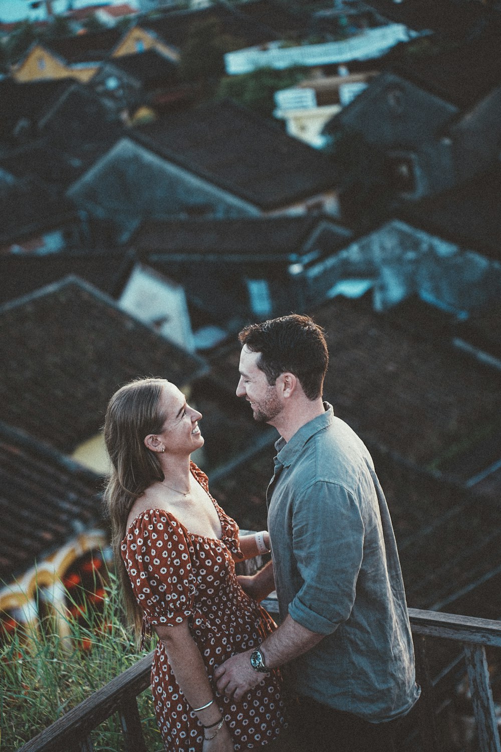 a man and woman standing on a balcony looking at each other