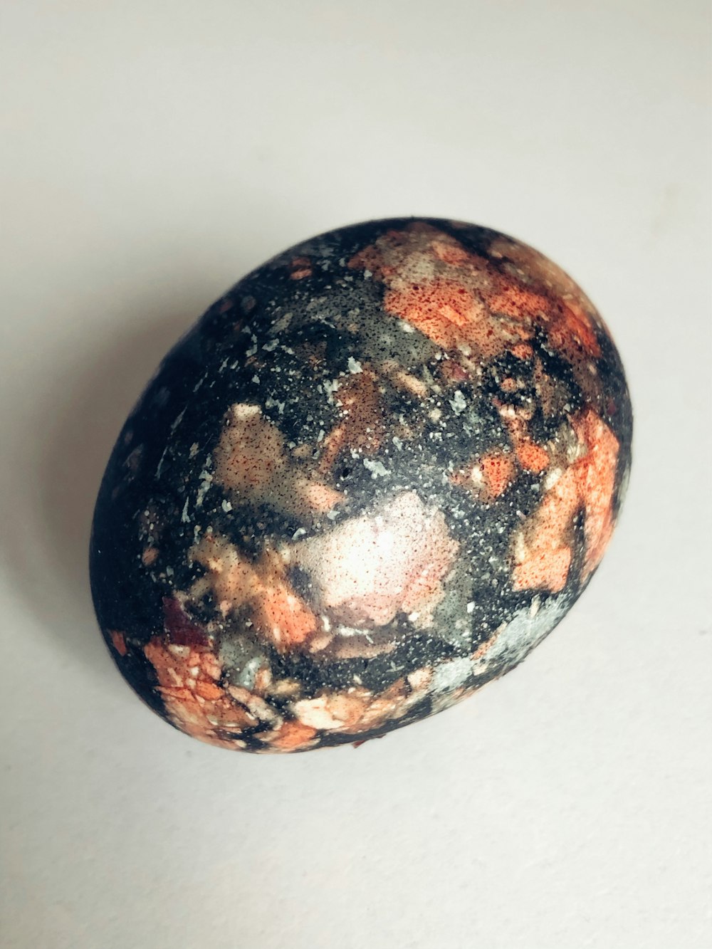 a black and red rock sitting on top of a white table