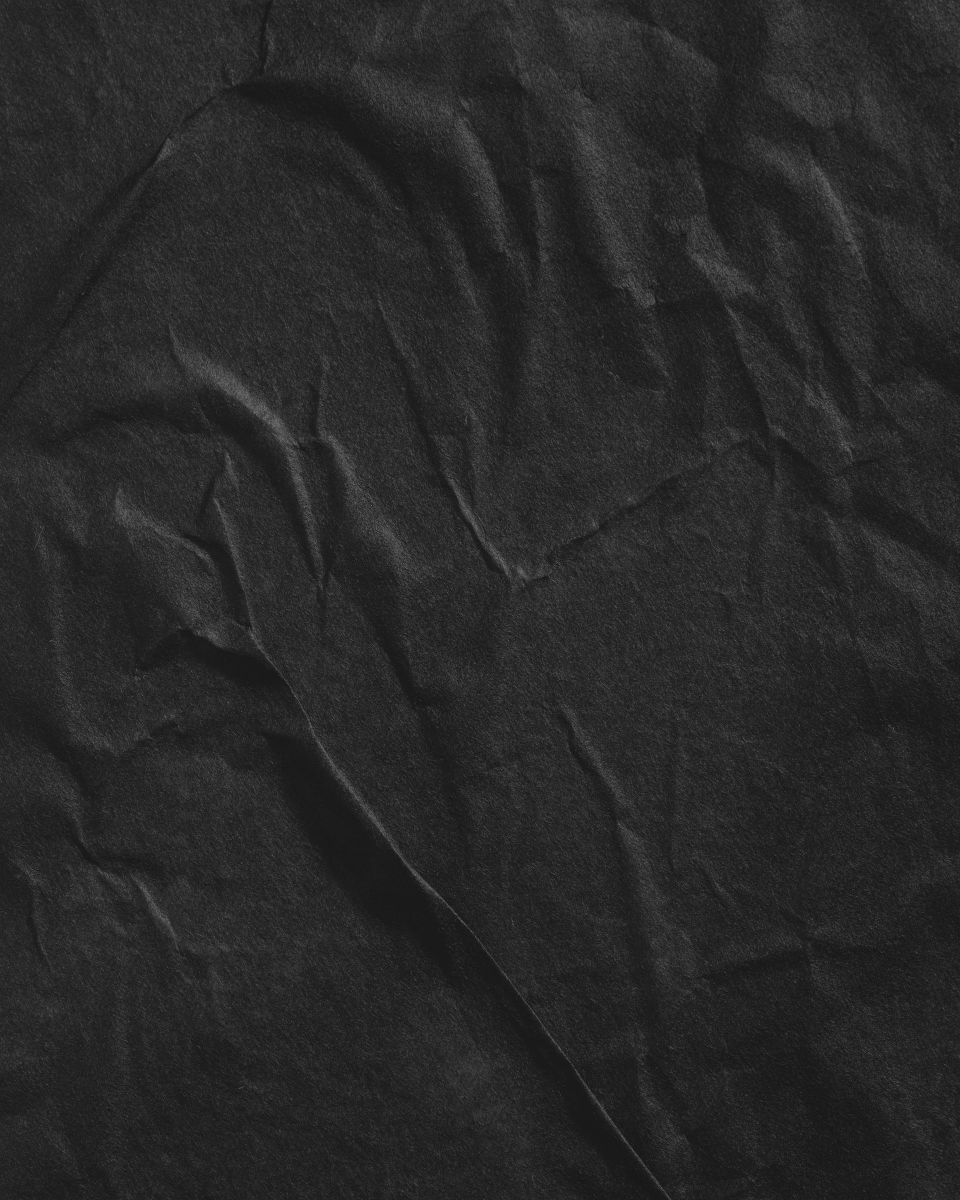 a black wrinkled paper textured with some folds