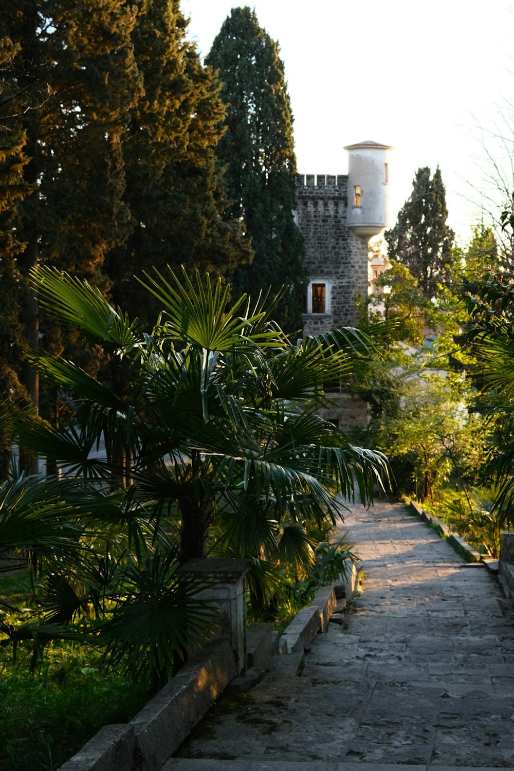 a stone path leading to a tower in the distance