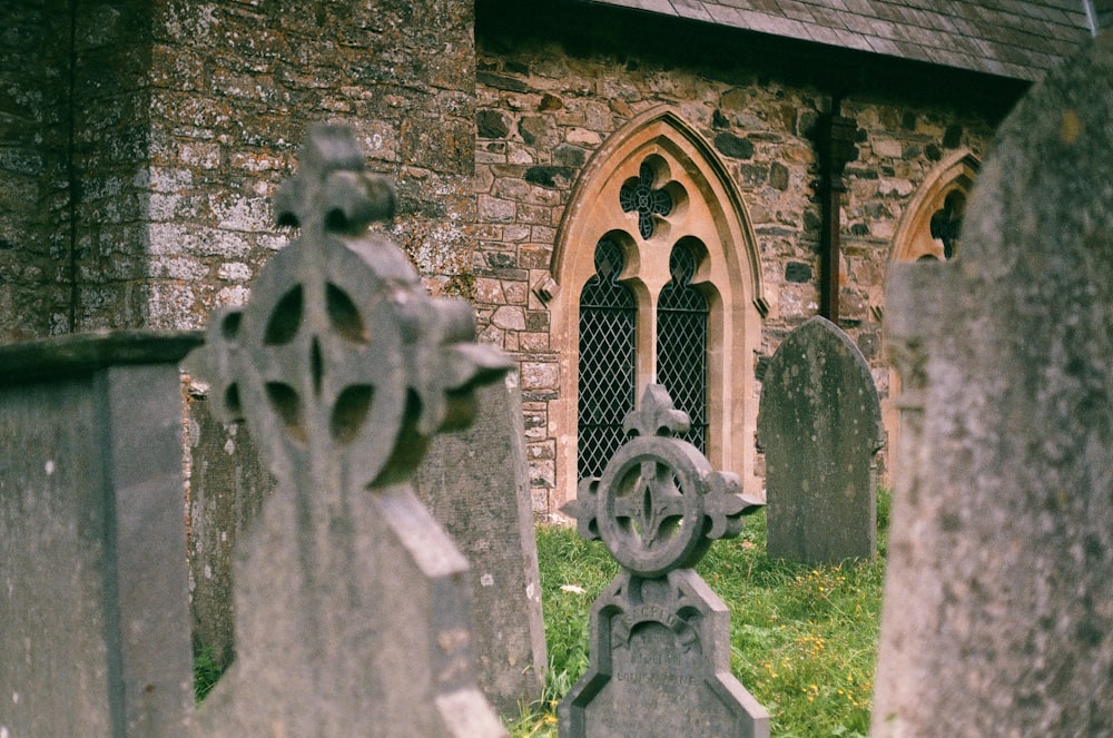 a cemetery with a stone building in the background