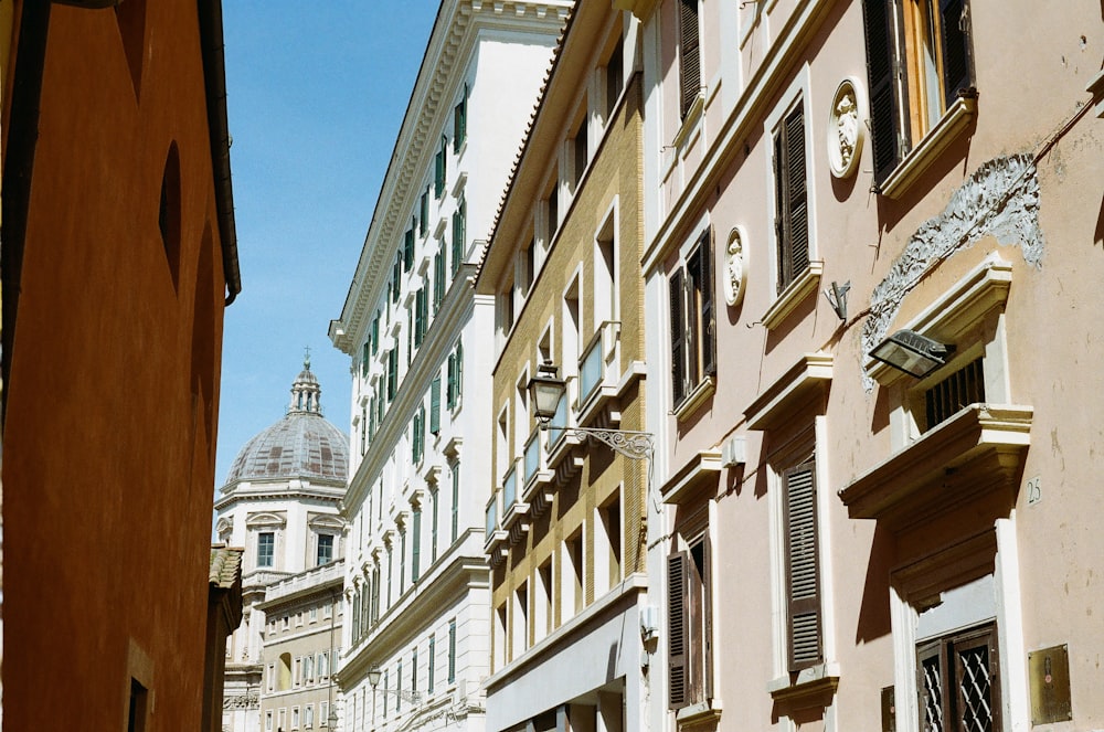 a row of buildings with a clock tower in the background