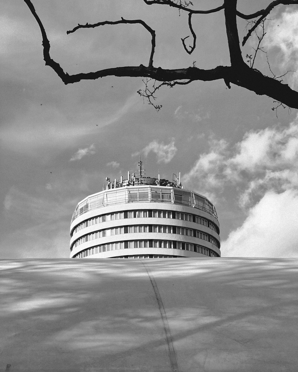 a round building sitting on top of a hill under a cloudy sky