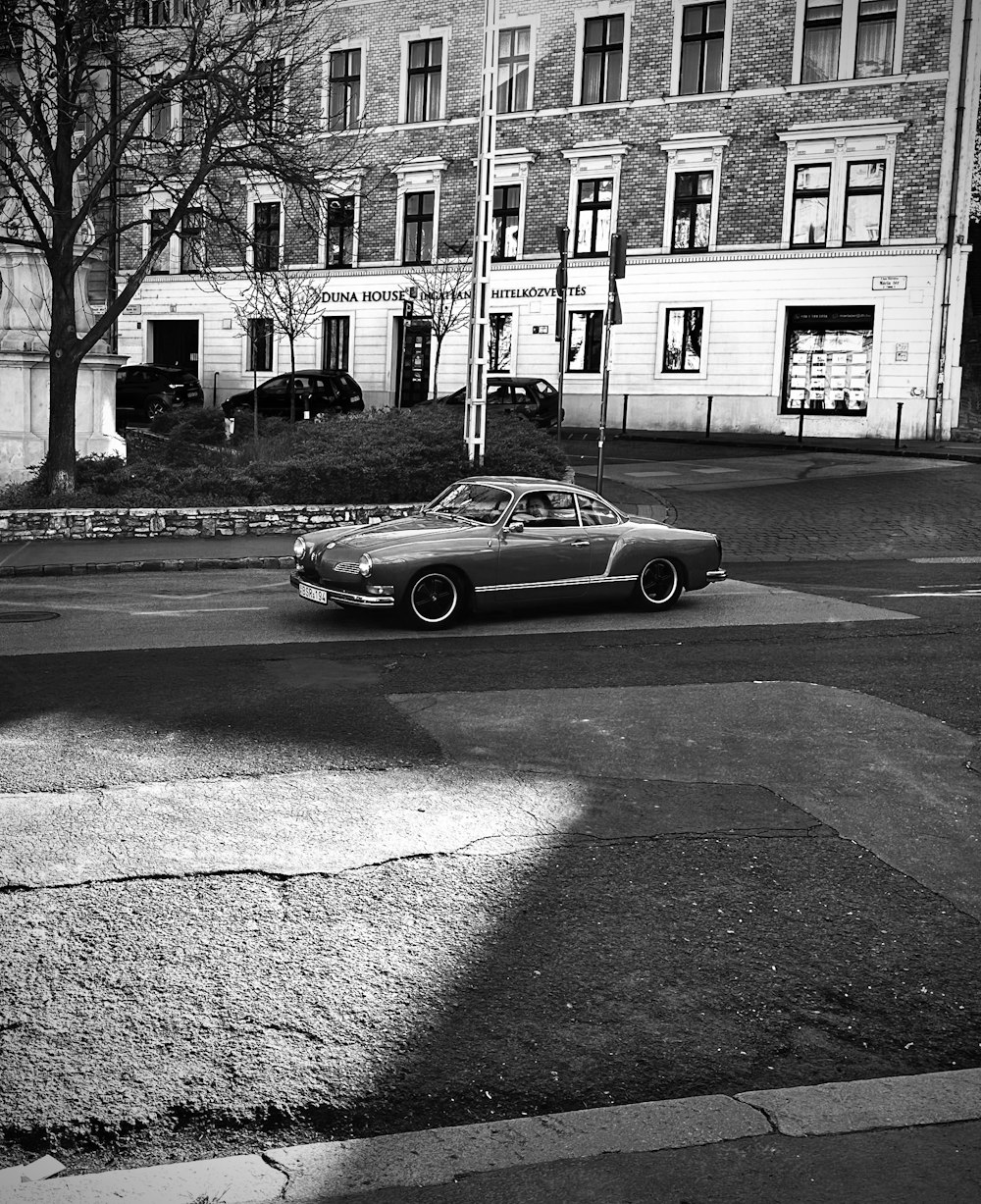 una foto en blanco y negro de un coche en una calle