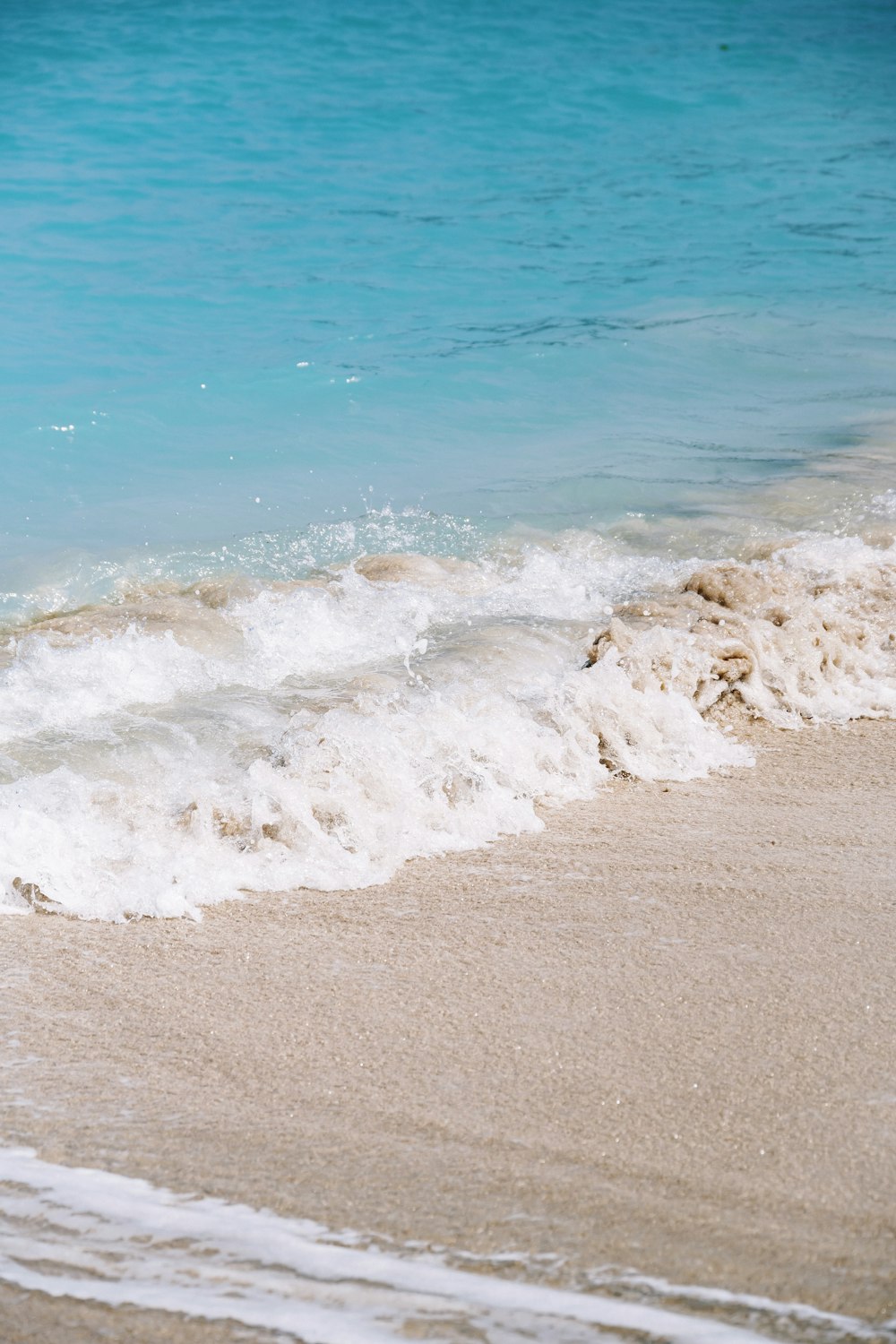 a person walking on the beach with a surfboard