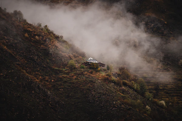 Mountain home in fog and storm weather