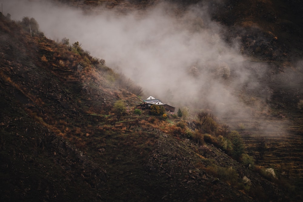 une maison sur une colline couverte de brouillard