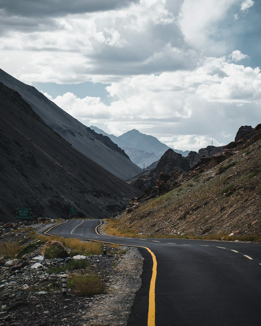 an empty road in the middle of a mountain range