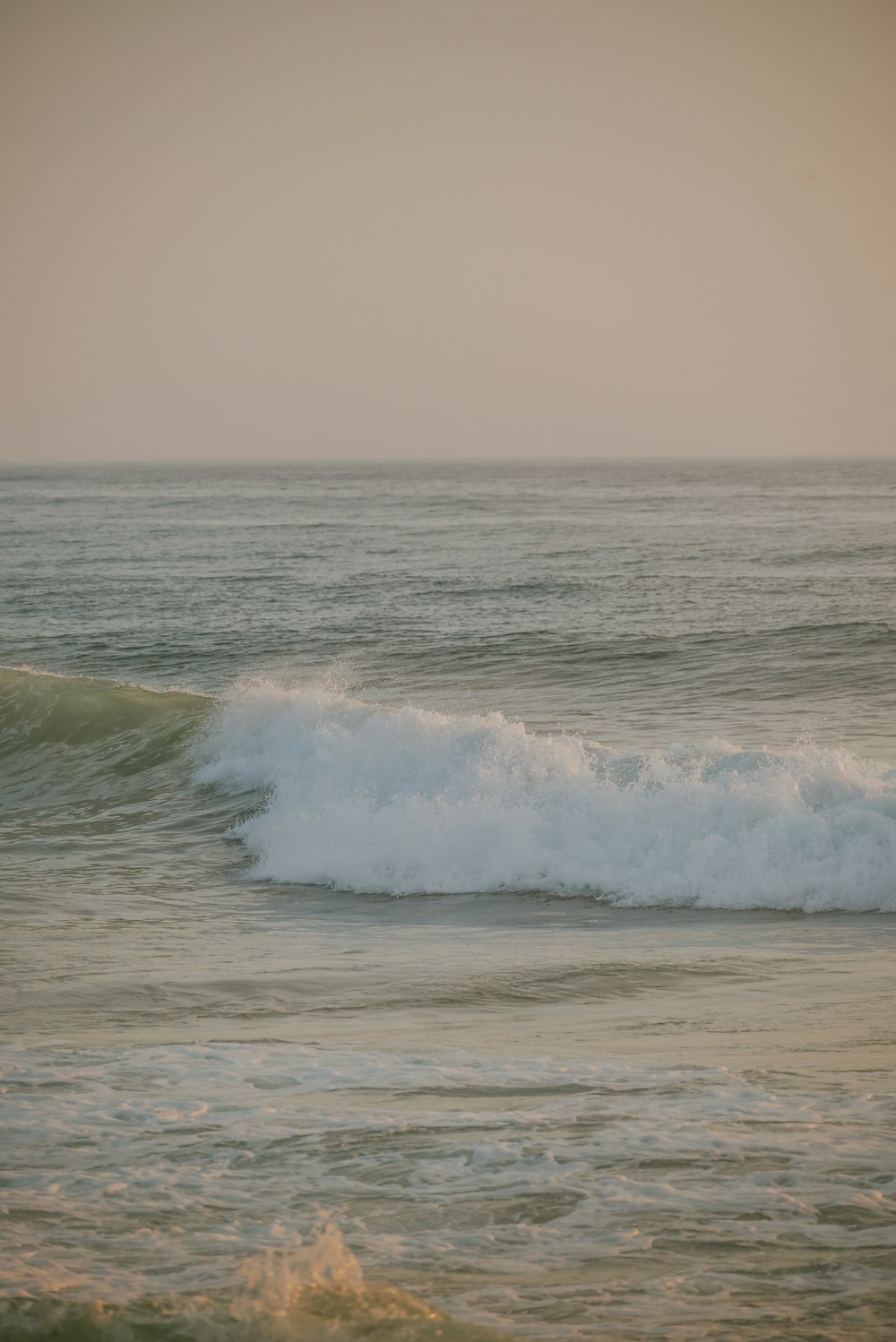 a man riding a wave on top of a surfboard