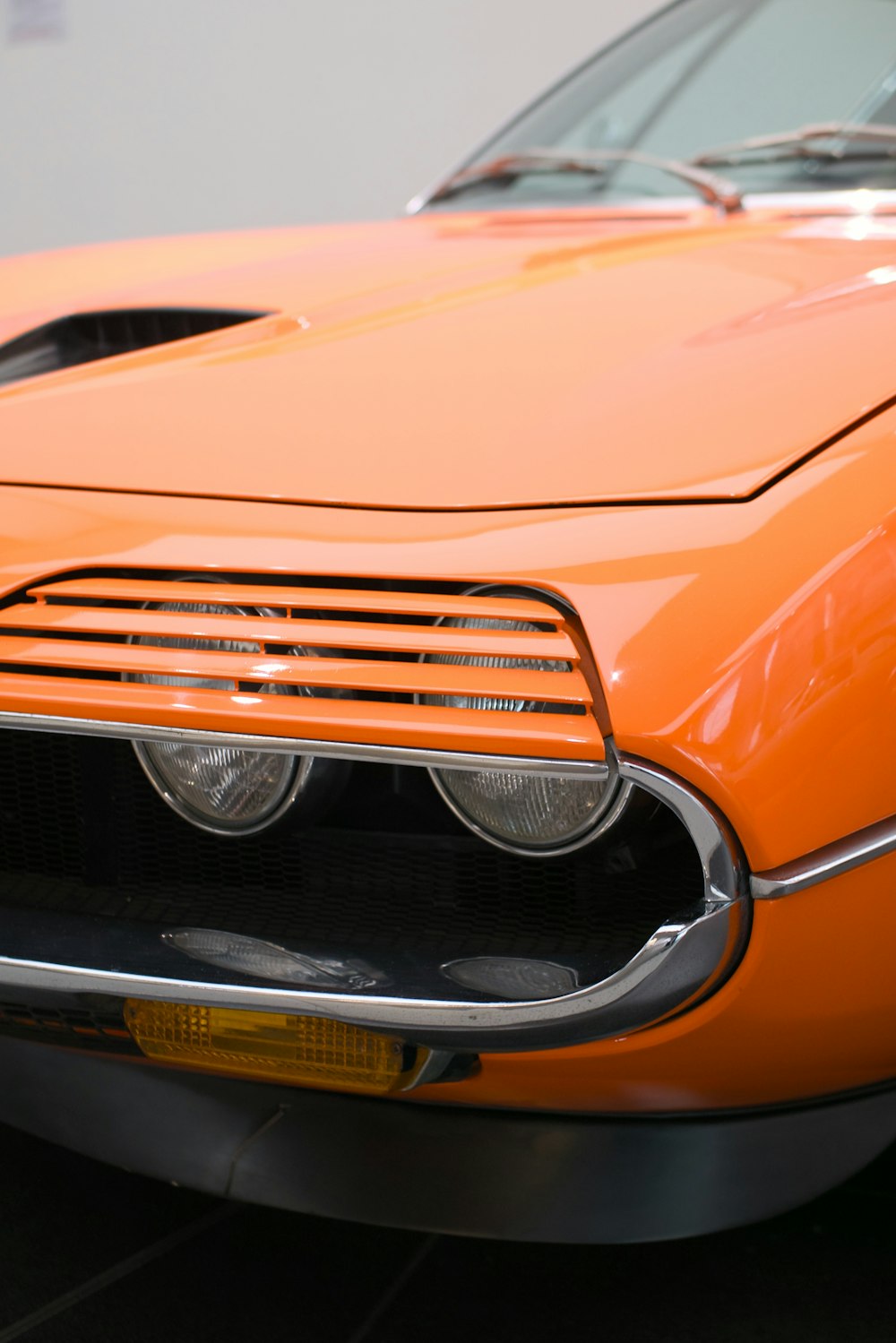 an orange sports car is parked in a garage