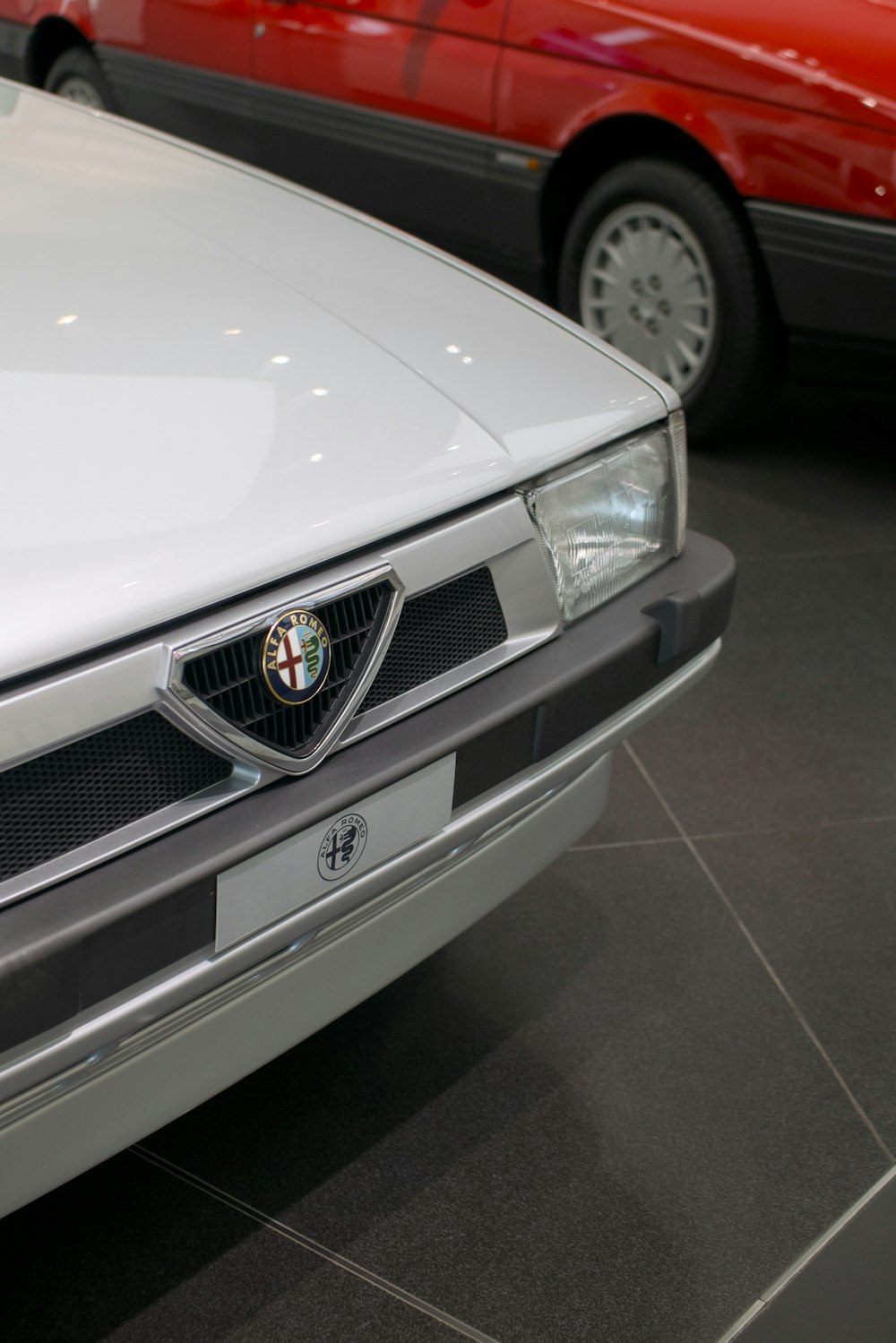 a white car is parked in a showroom