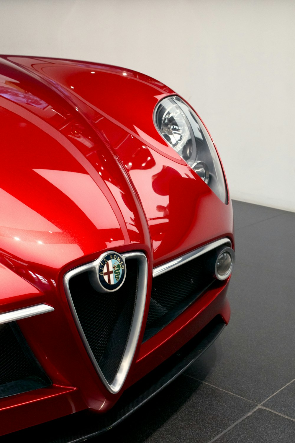 a close up of a red sports car on a black floor