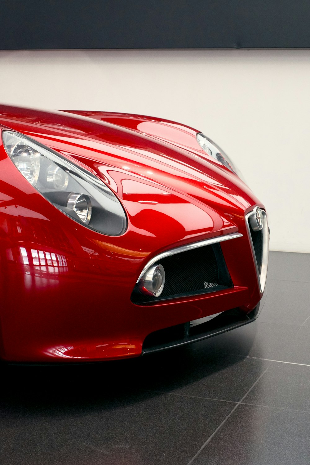 a close up of a red sports car on a tile floor