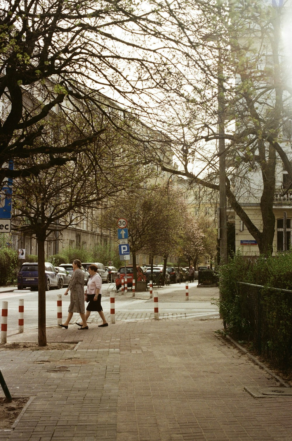 a couple of people walking down a sidewalk