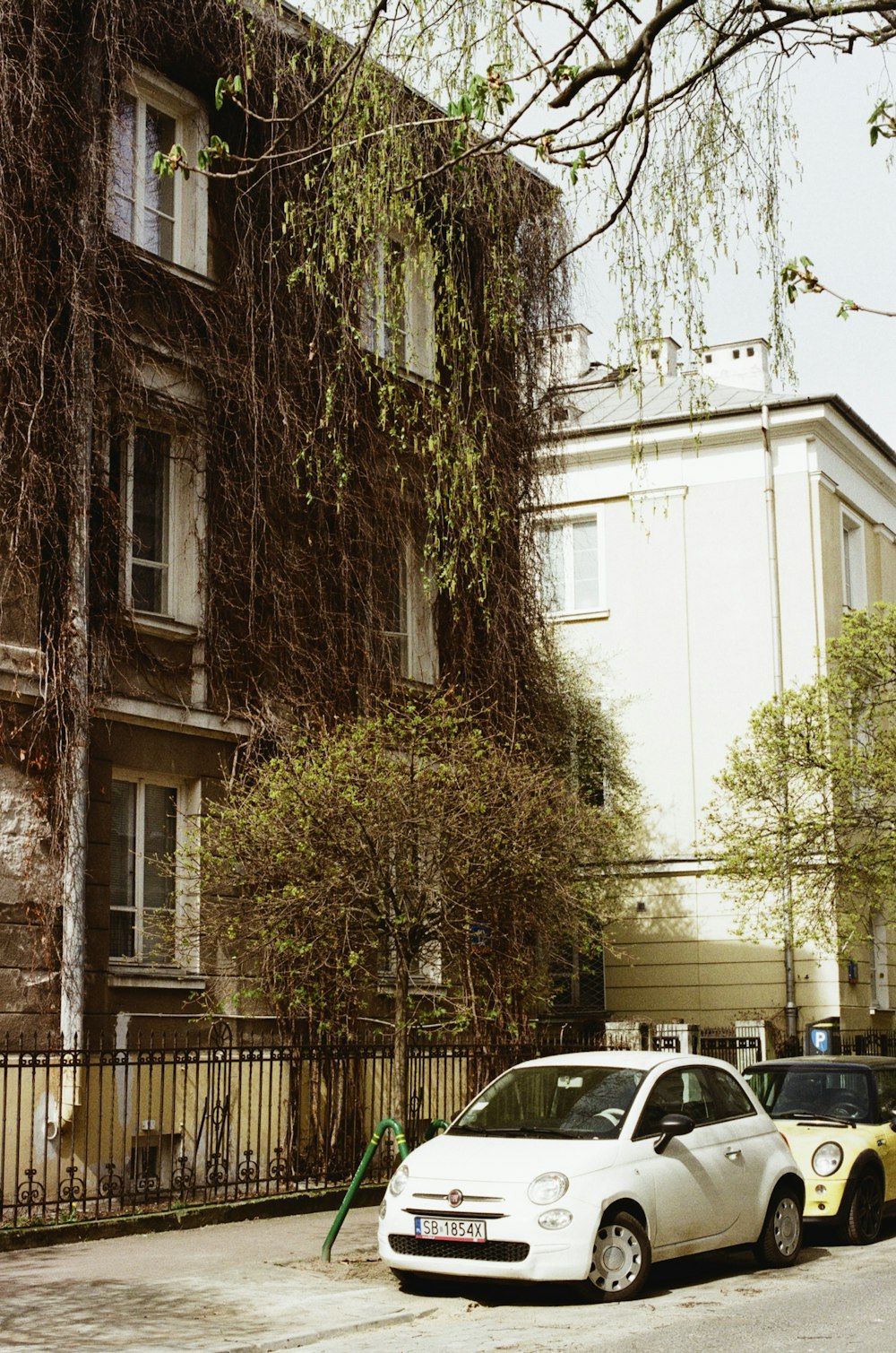 a white car parked in front of a tall building