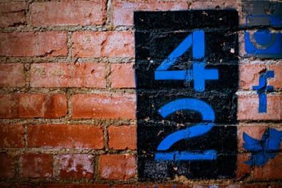 a brick wall with blue numbers painted on it