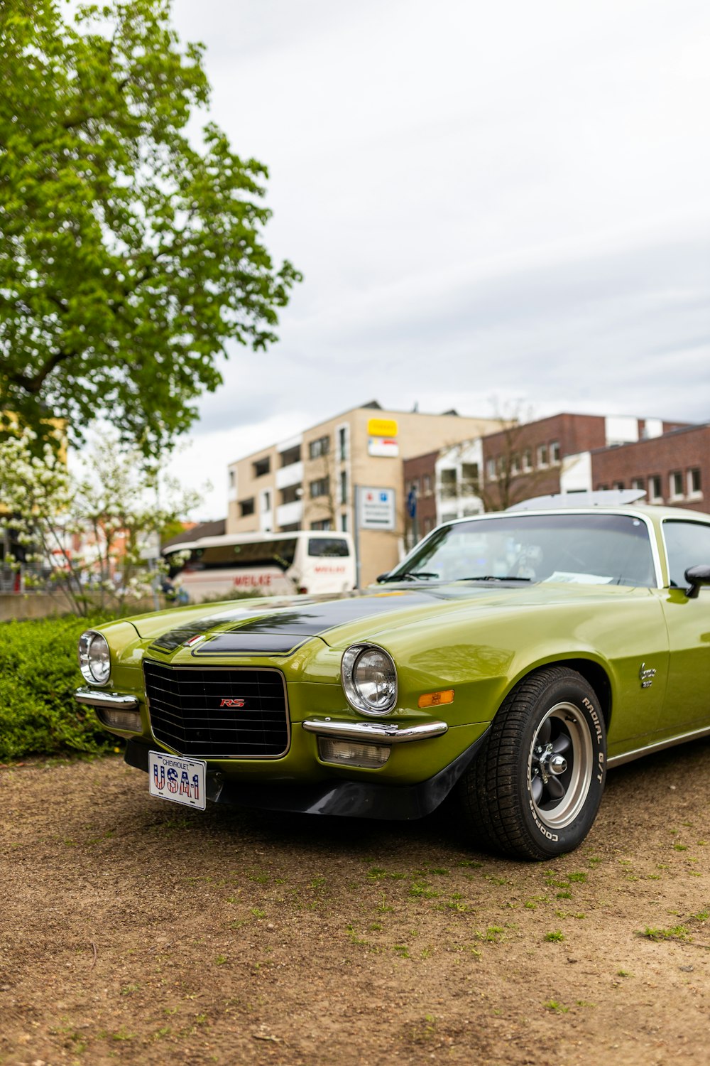 a green car parked on a dirt road