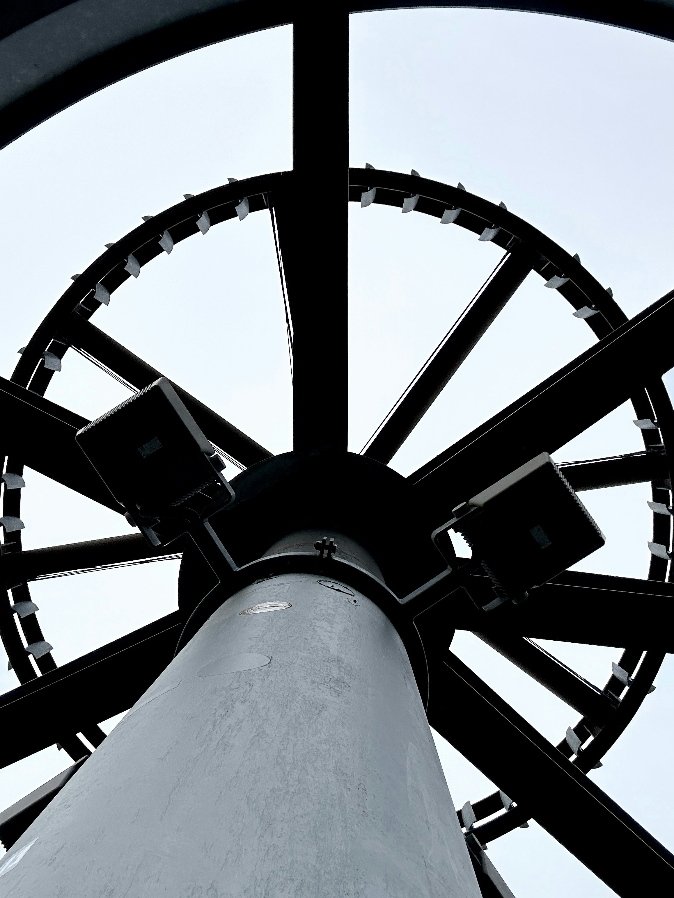 Dramatic low-angle view of a large construction project under night lighting, dark steel structures, atmospheric industrial lighting