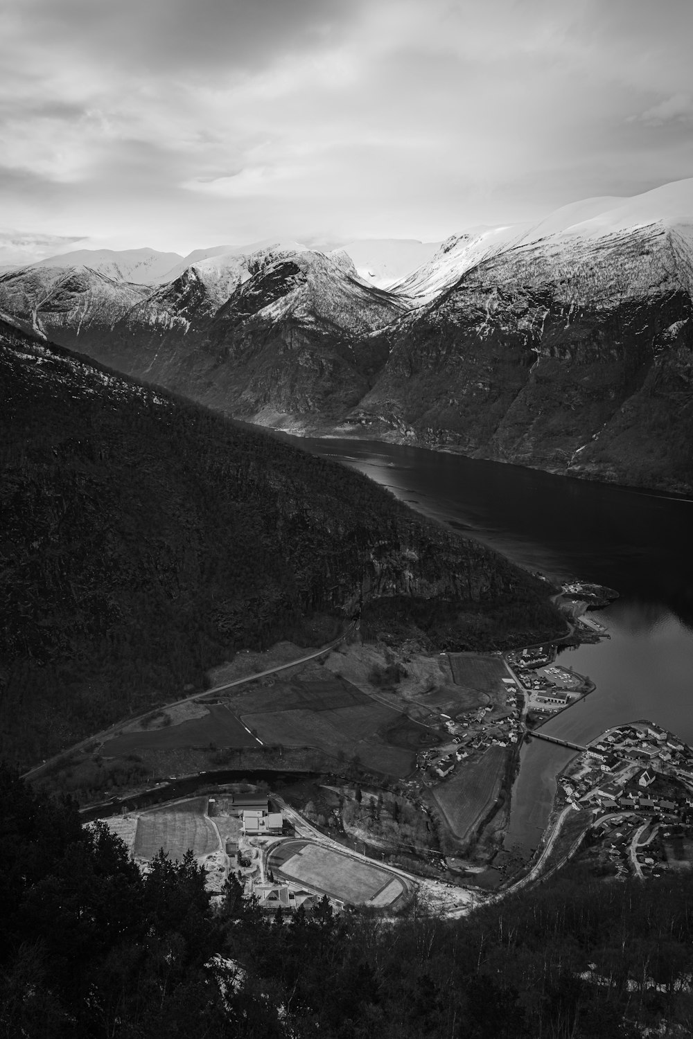 a black and white photo of a lake and mountains