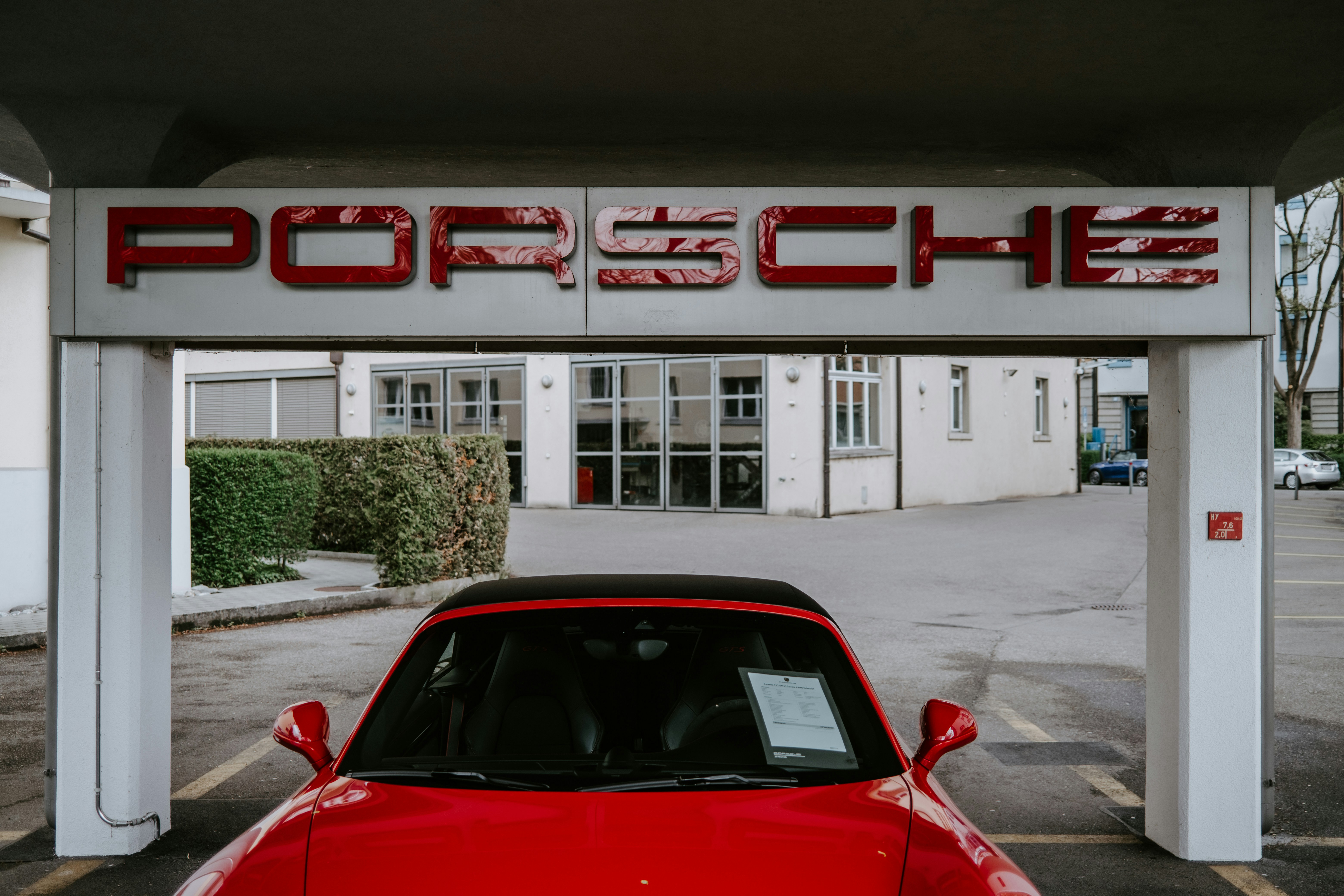 Porsche Taycan electric sedan driving through a modern city street at dusk