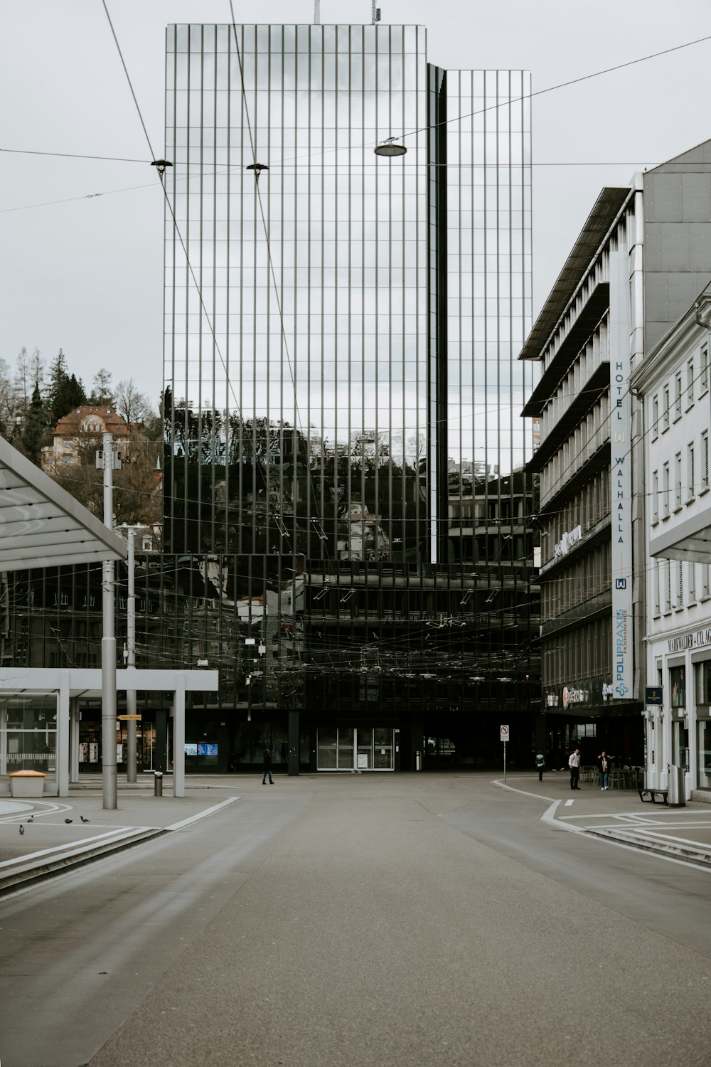 an empty city street with a tall building in the background