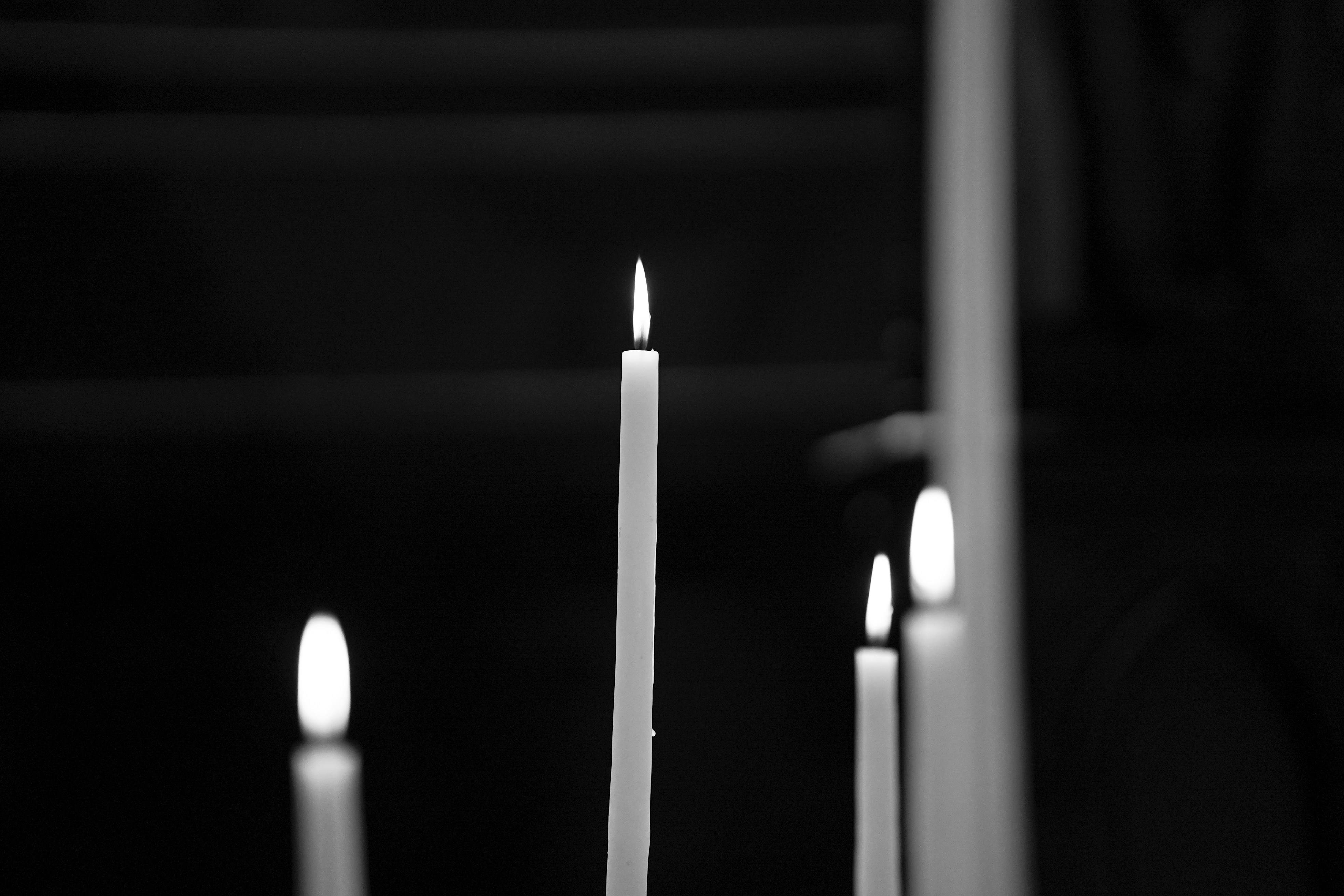 a black and white photo of candles in a church
