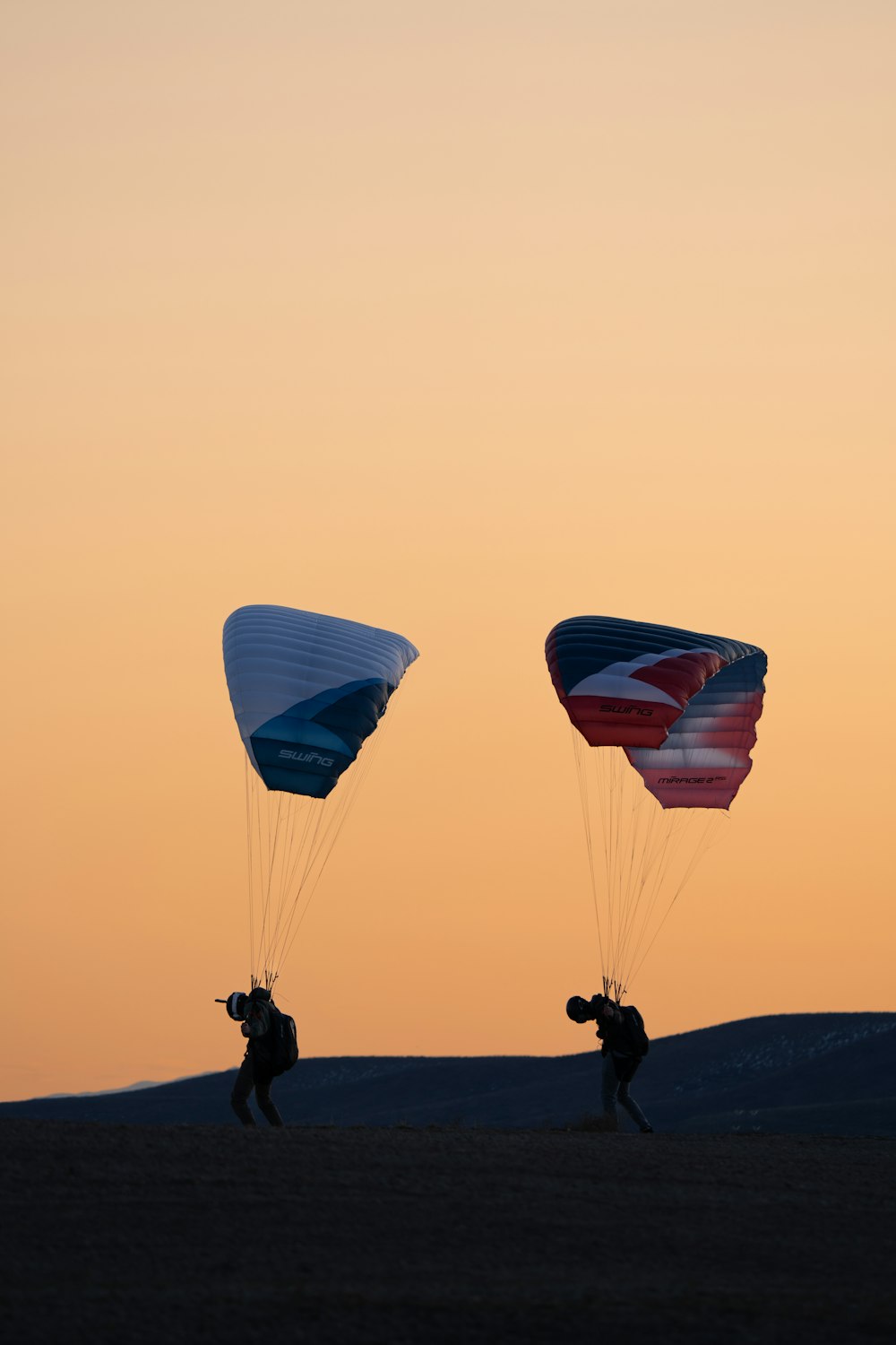 a couple of people that are flying some kites