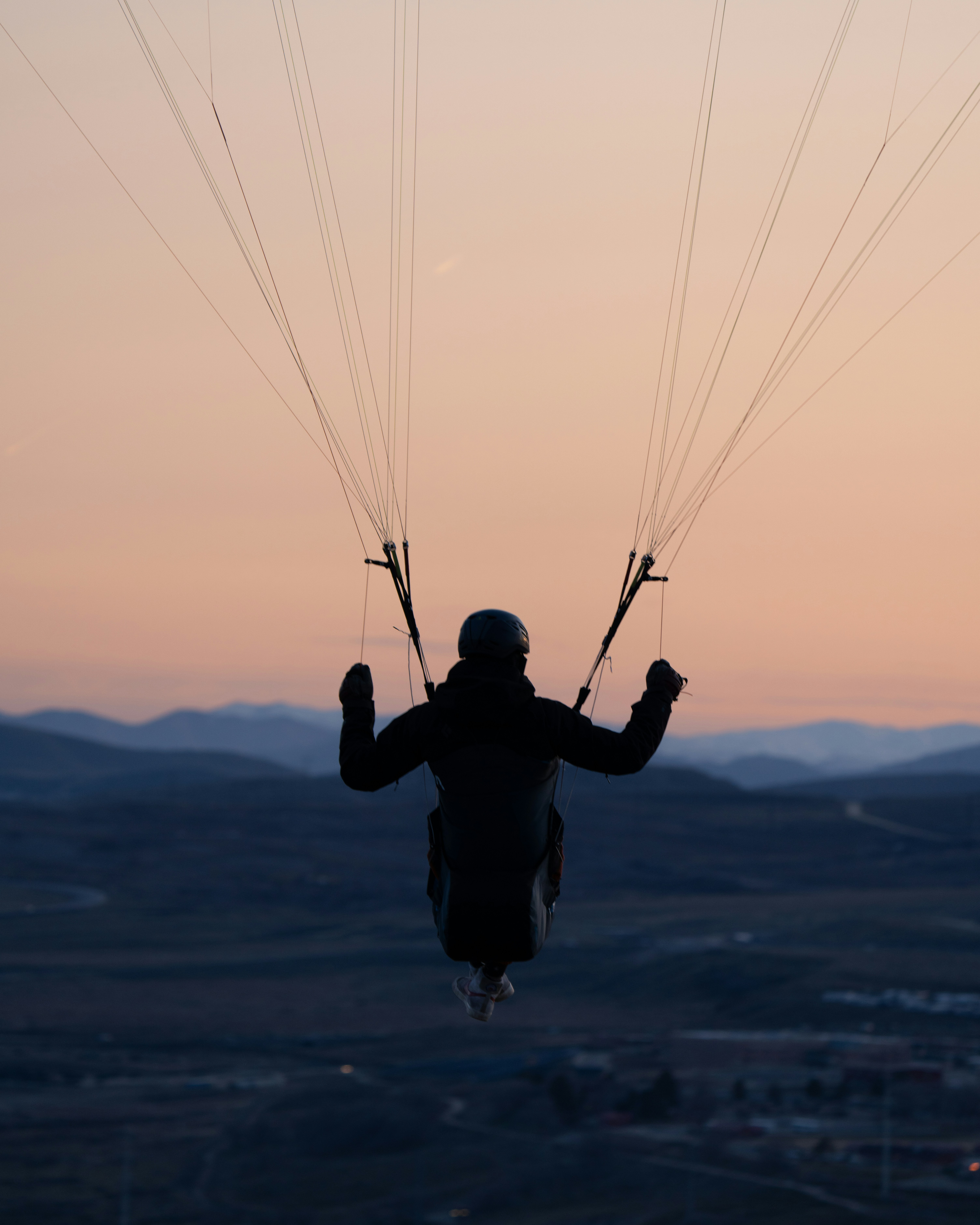 a person is parasailing in the air at sunset