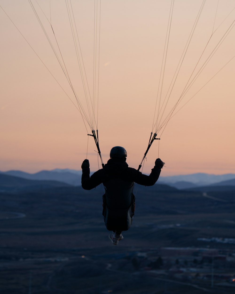 a person is parasailing in the air at sunset