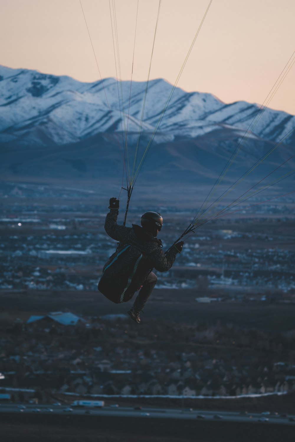 a man flying through the air while holding onto a parachute