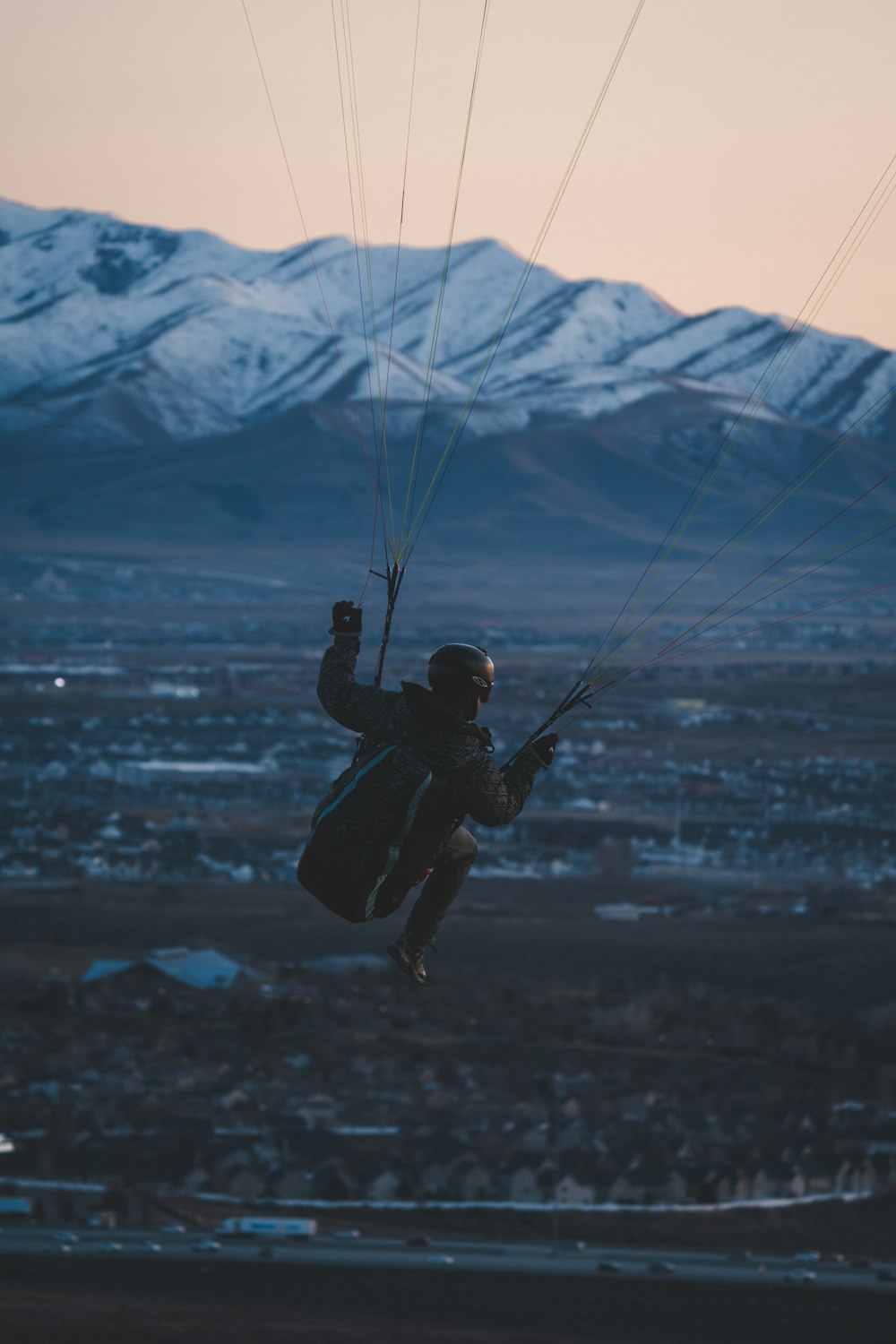 un homme volant dans les airs tout en s’accrochant à un parachute