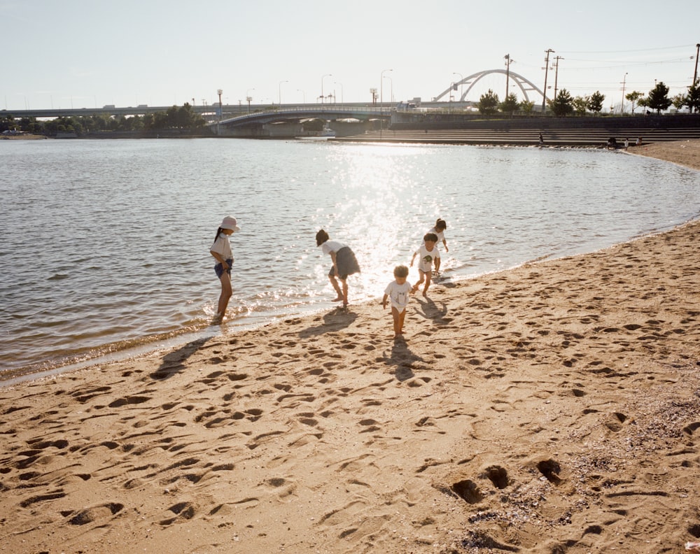 a group of people standing on top of a sandy beach