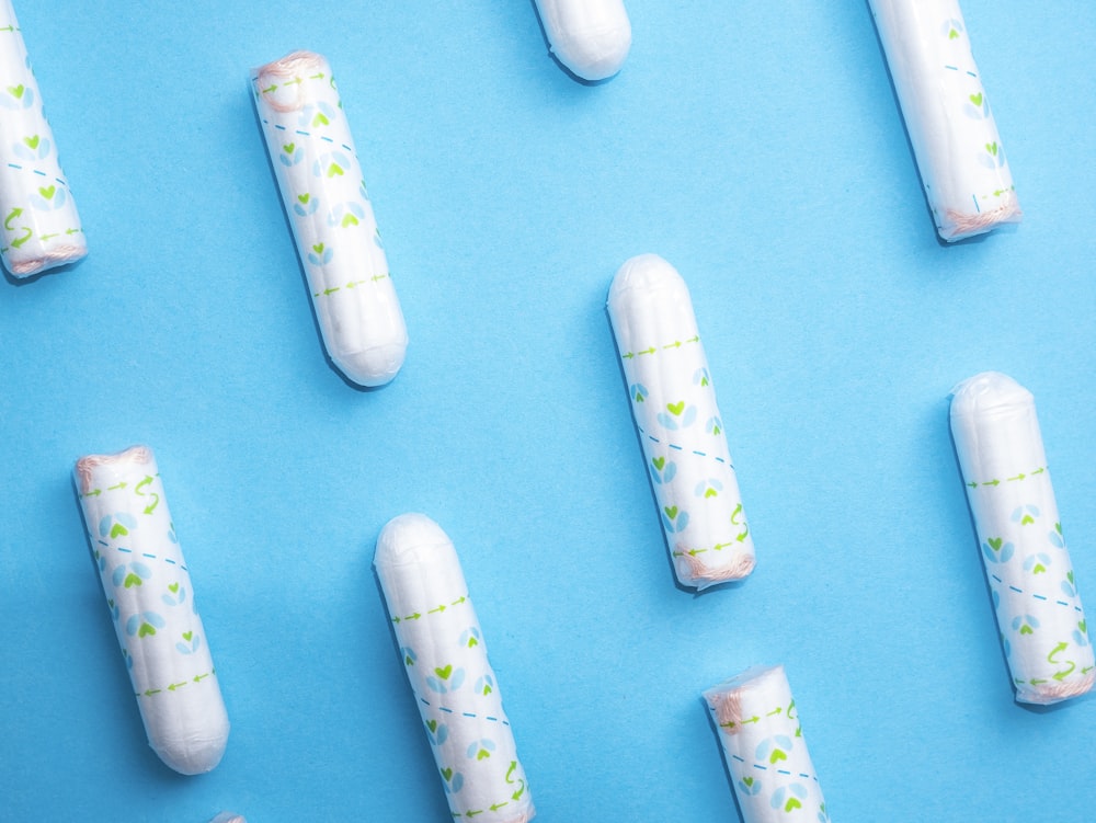 a group of white pills sitting on top of a blue surface