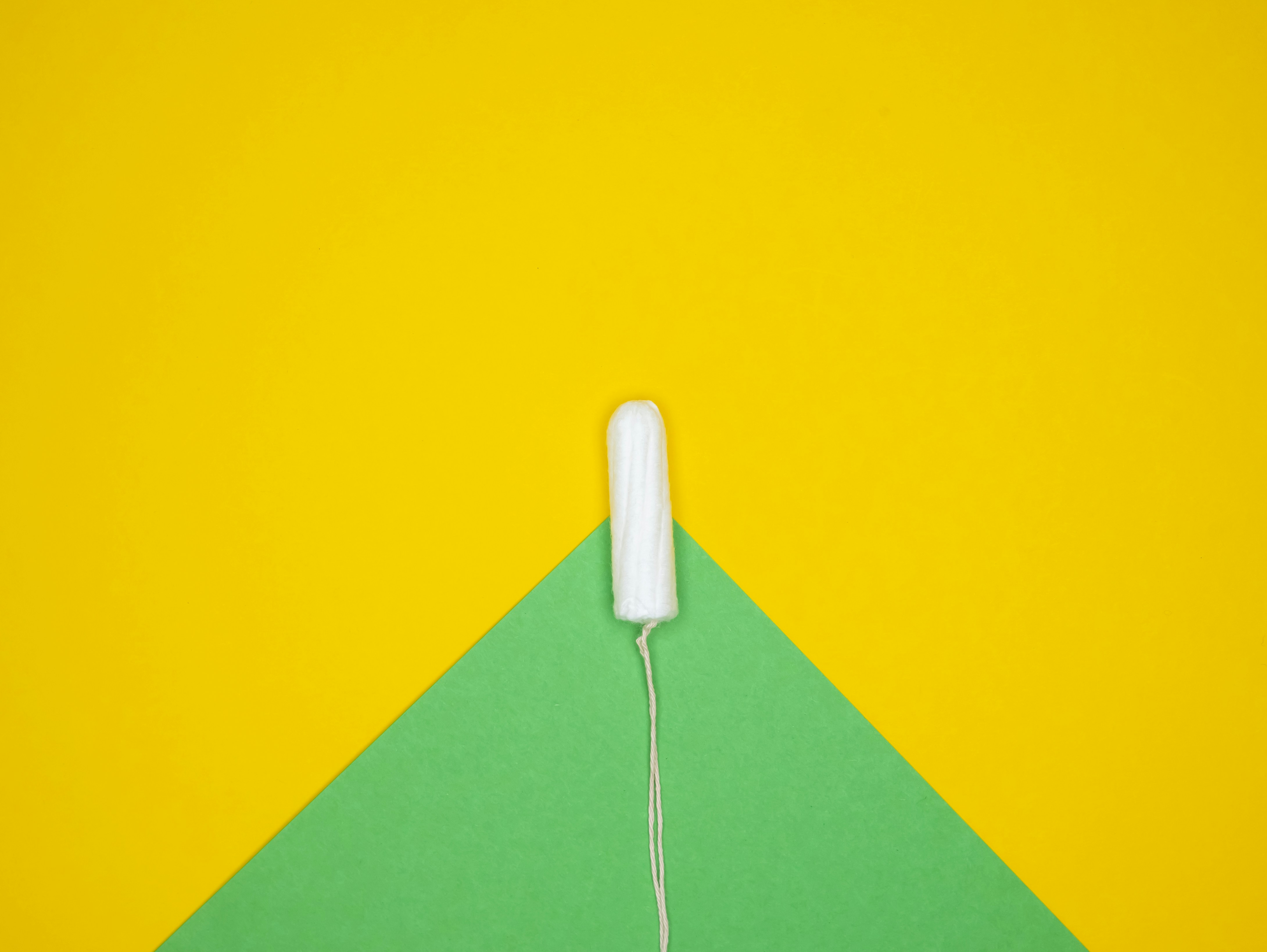 a nintendo wii controller sitting on top of a green and yellow triangle