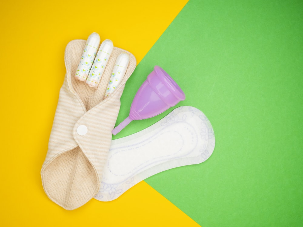 a pair of gloves and a baby bottle on a yellow and green background