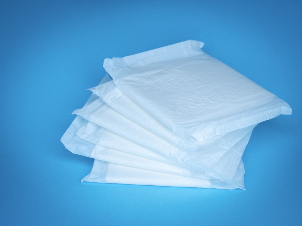 Ein Haufen weißer Taschentücher sitzt auf einem blauen Tisch
