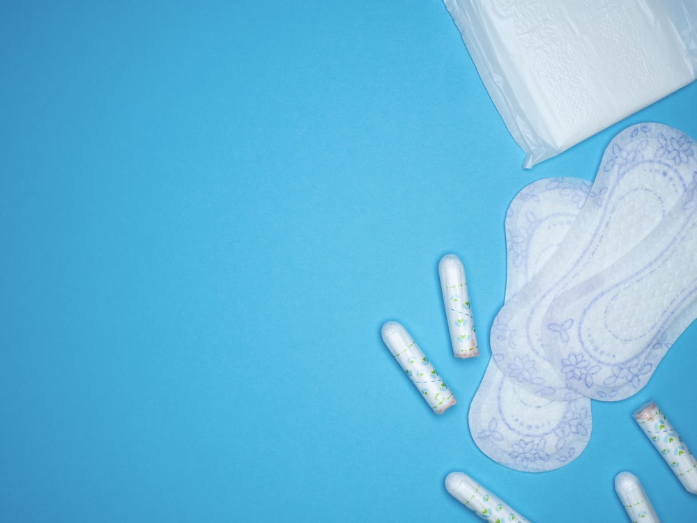 a pair of sanitary pads next to a bag of sanitary wipes