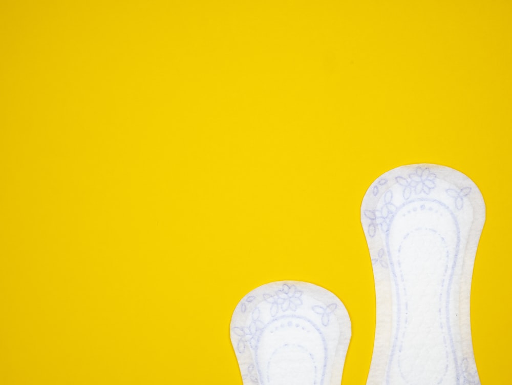 a pair of white shoes on a yellow background