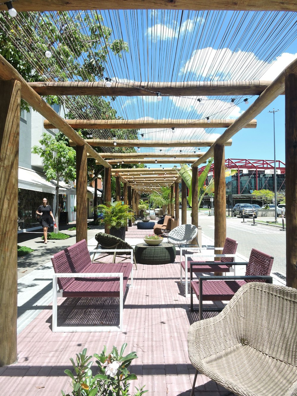 a covered patio with wicker furniture and plants