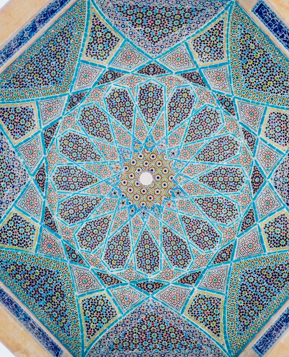 an intricate blue and green pattern on the ceiling of a building