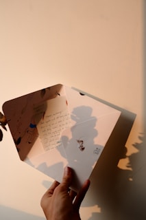 a person holding a piece of paper with a shadow on it