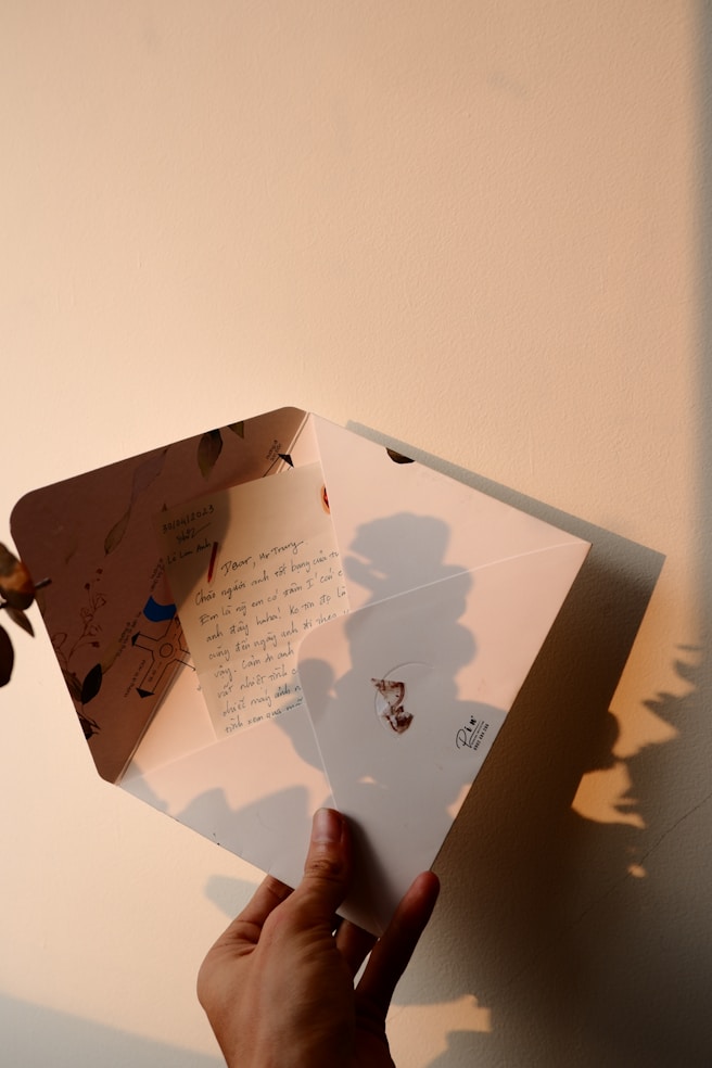 a person holding a piece of paper with a shadow on it