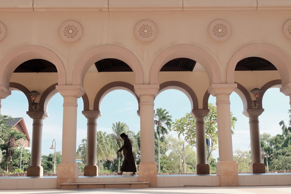 a woman standing under an archway in a building