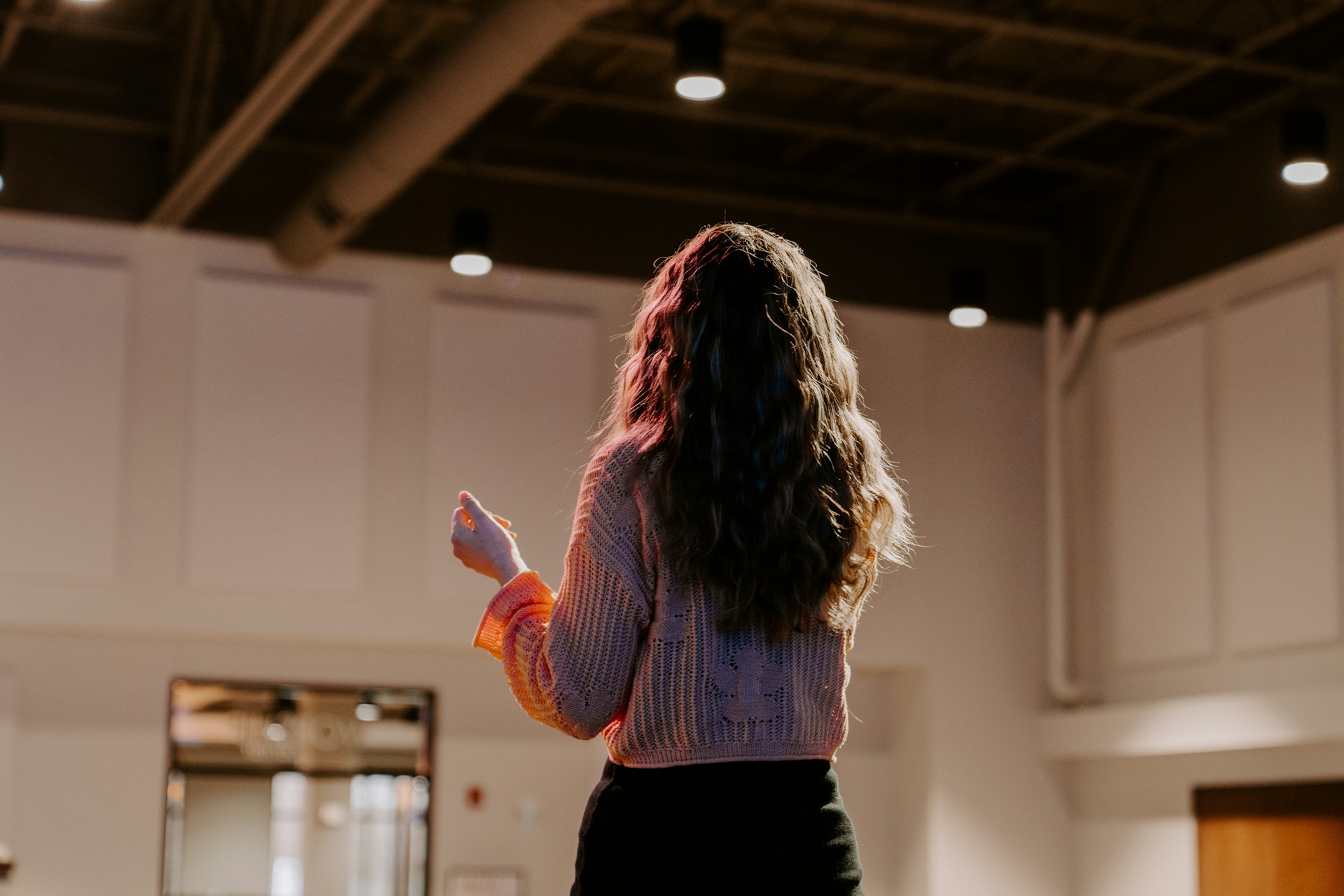 a woman standing in a room holding a remote