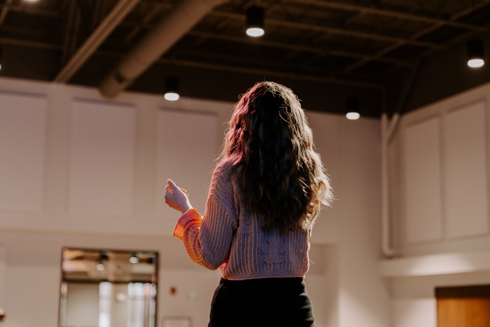 a woman standing in a room holding a remote