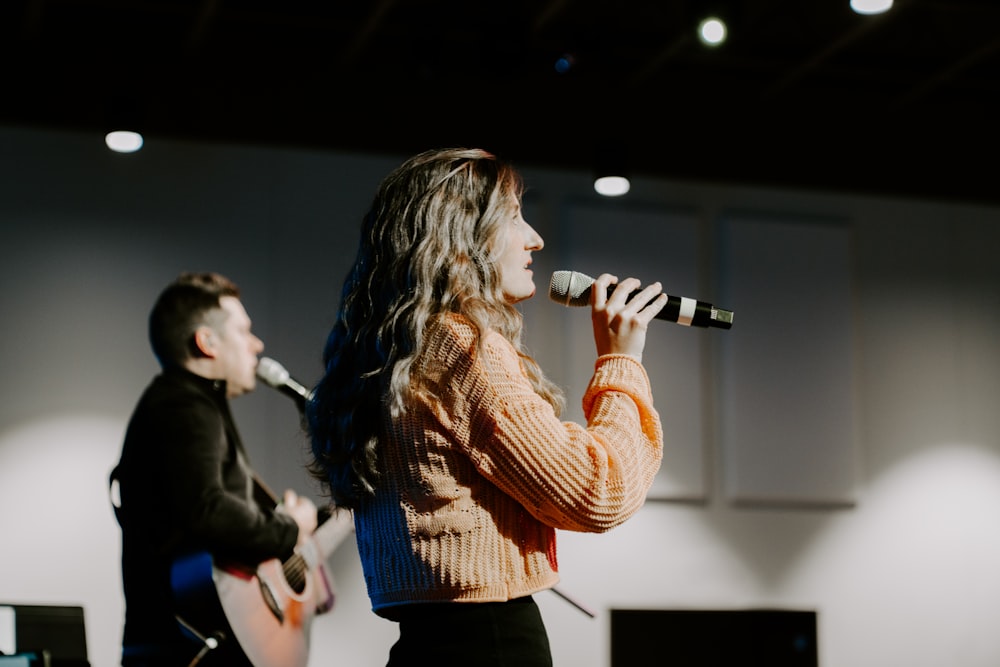 a man and a woman singing into microphones