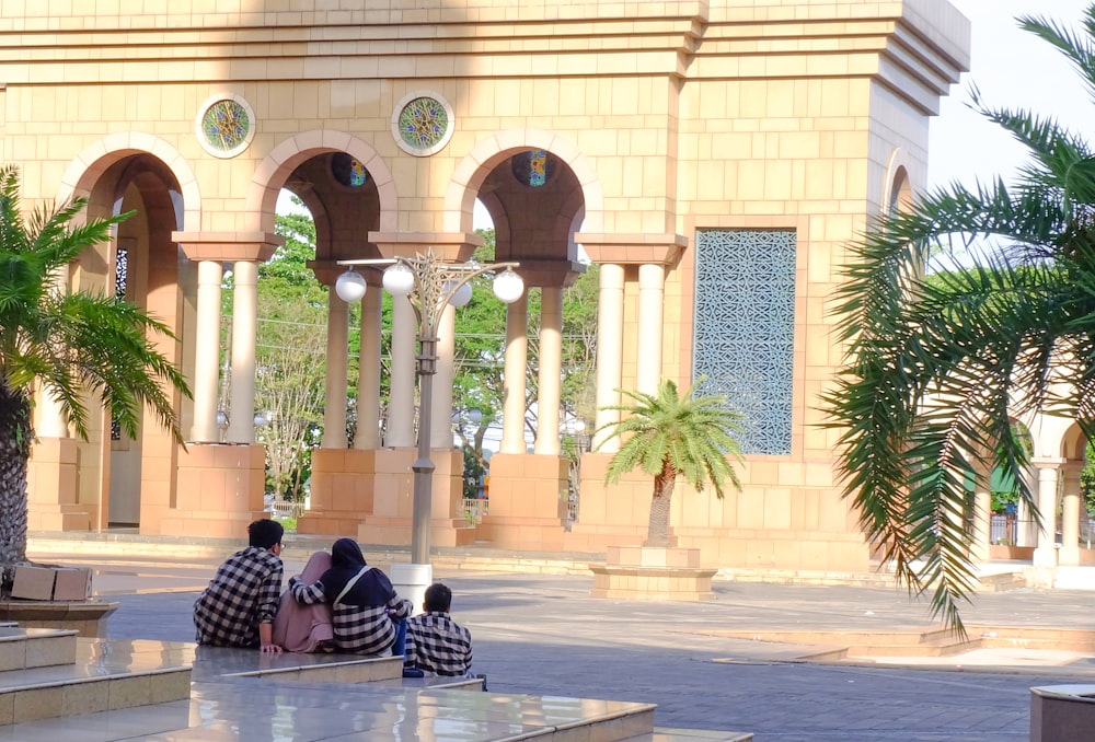 a group of people sitting on steps in front of a building