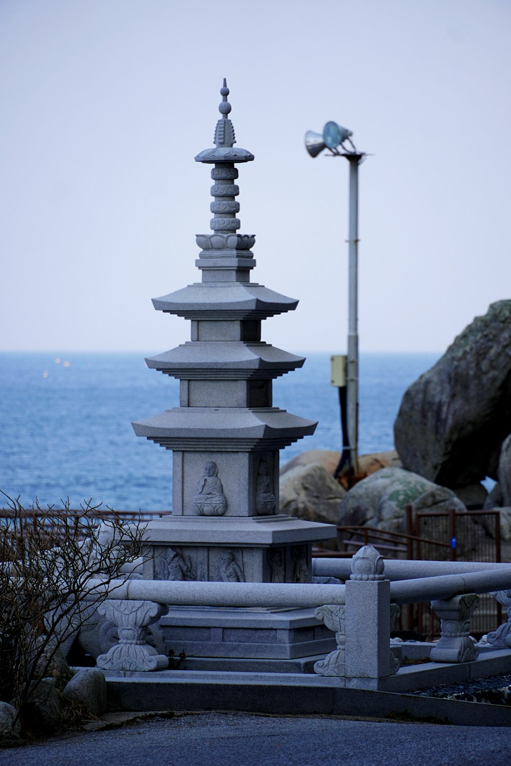 a tall white tower sitting next to the ocean