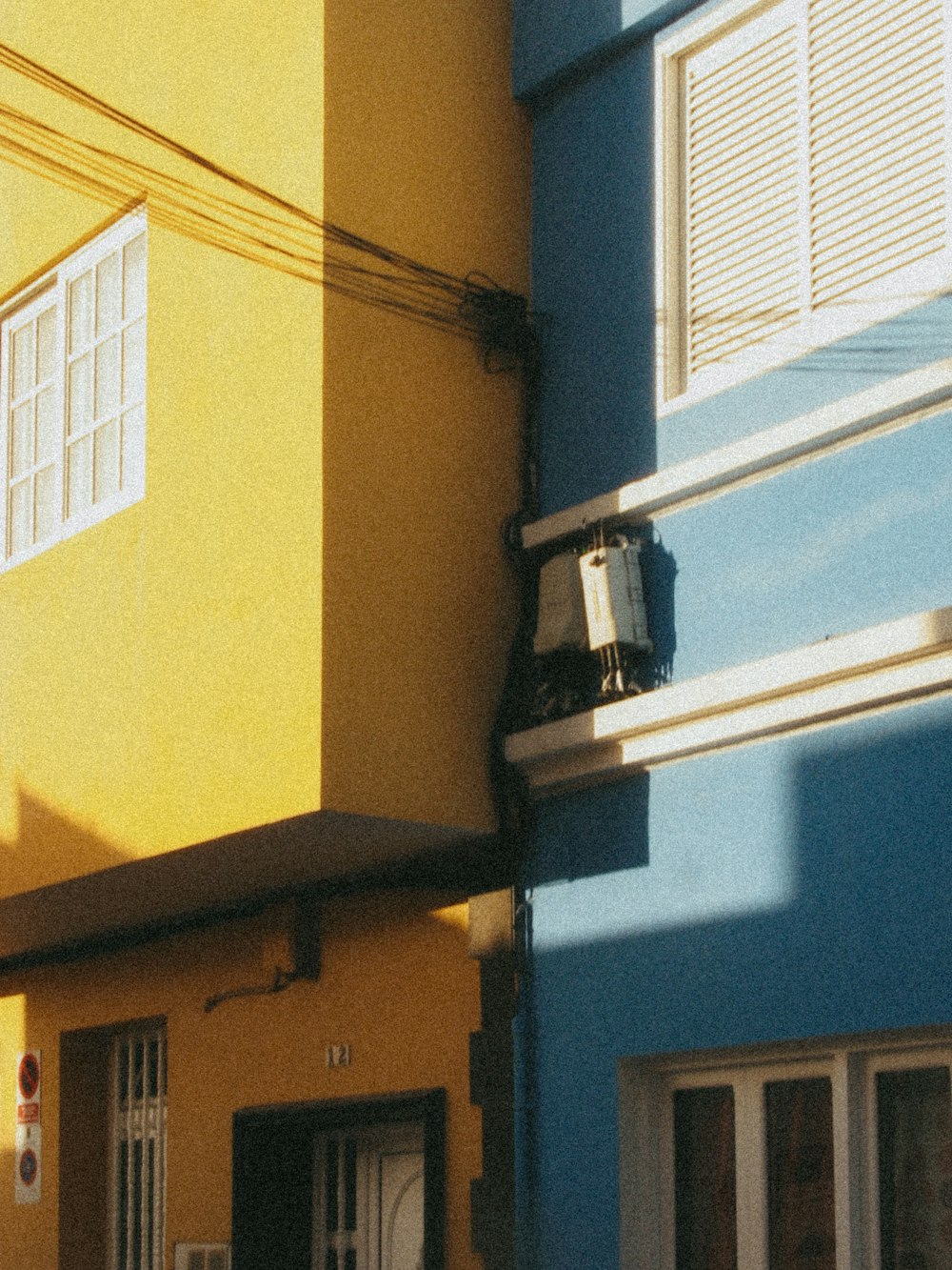 a yellow and blue building with a clock on the side